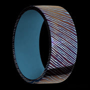 9 mm wide Flat Titanium Damascus band featuring a Royal Blue sleeve.